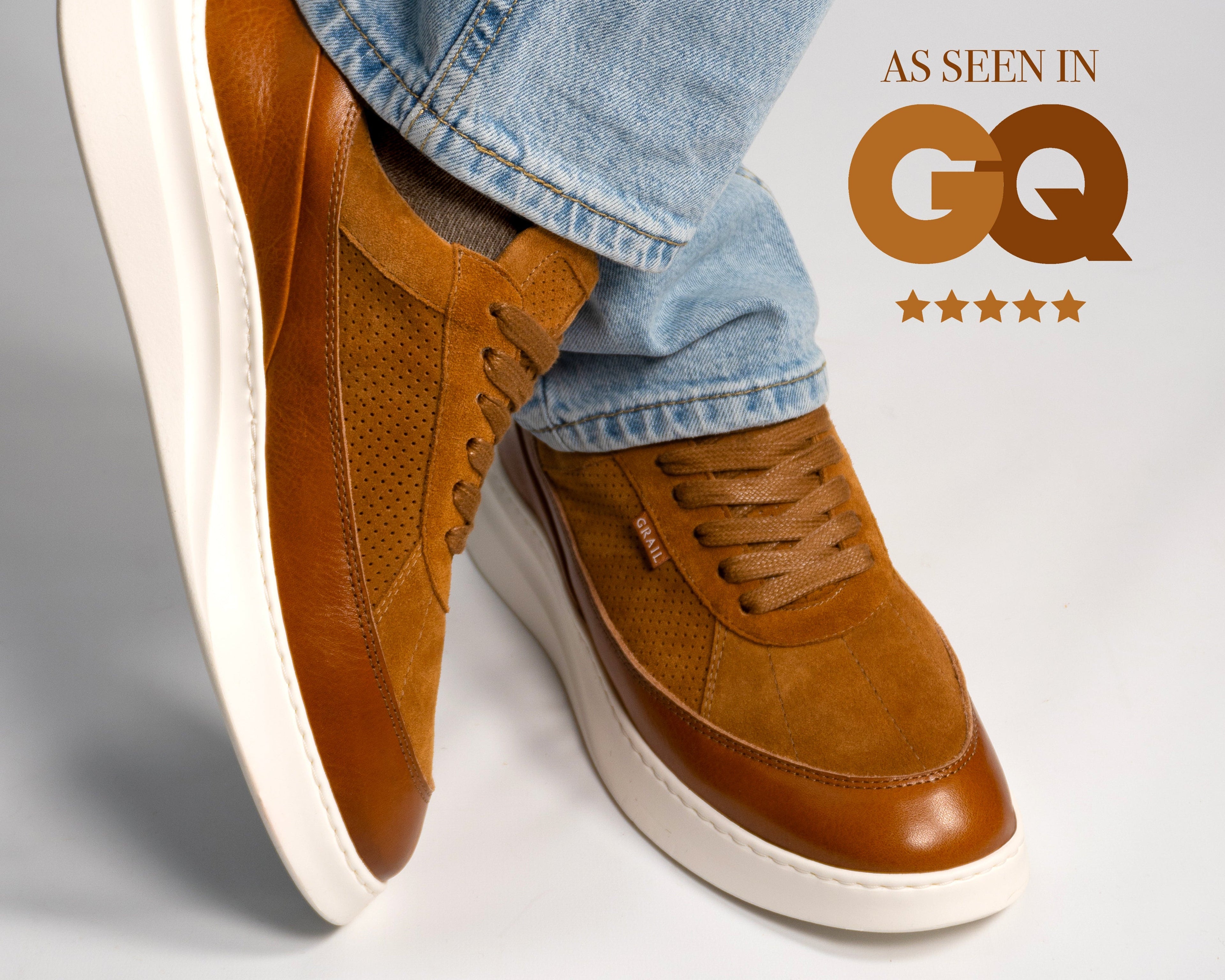 Brown leather shoes with white soles worn with light blue jeans on a gray background, featuring GQ logo.